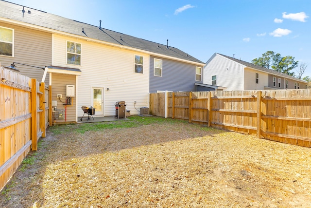 back of house with a fenced backyard, a patio, and central AC unit