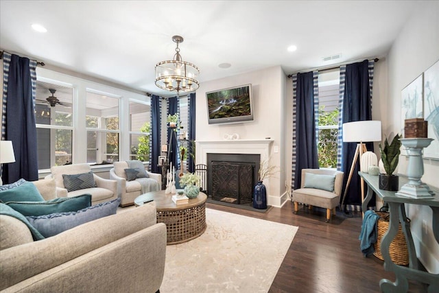 living room with an inviting chandelier, a wall of windows, dark hardwood / wood-style floors, and a wealth of natural light