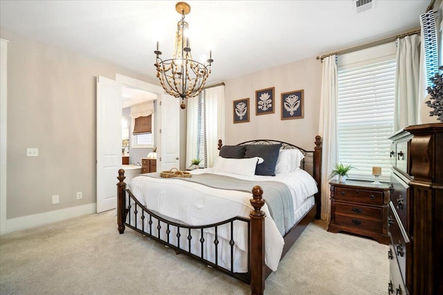 carpeted bedroom featuring a notable chandelier and ensuite bathroom