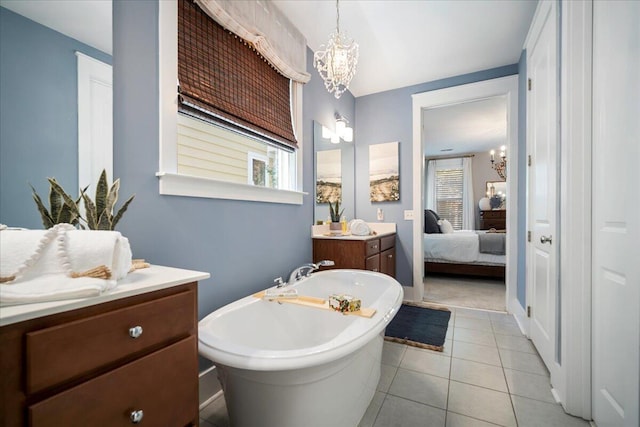 bathroom with vanity, a bathing tub, an inviting chandelier, and tile patterned flooring