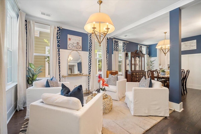 living room with wood-type flooring, an inviting chandelier, and plenty of natural light