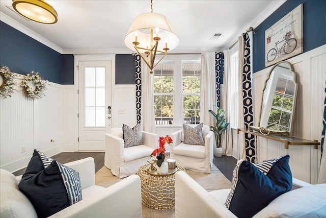 living room featuring hardwood / wood-style flooring, ornamental molding, and a chandelier