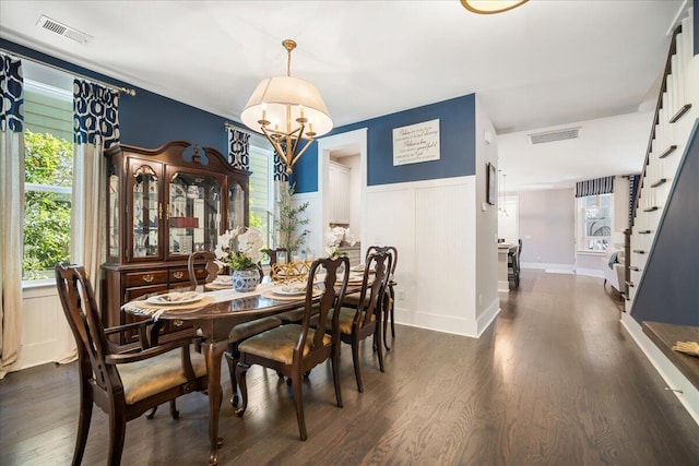 dining room with dark hardwood / wood-style floors and a notable chandelier