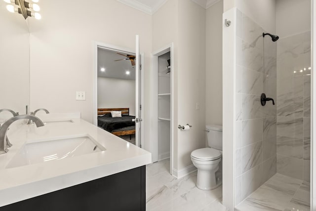 bathroom with toilet, a sink, marble finish floor, a tile shower, and crown molding