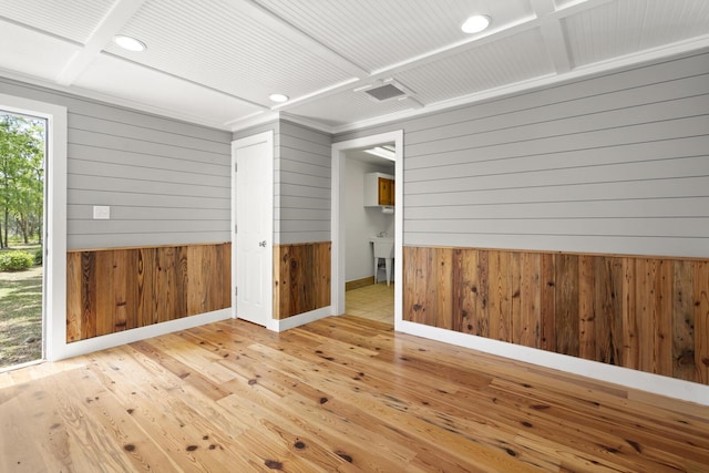 empty room with hardwood / wood-style floors, wood walls, recessed lighting, and baseboards