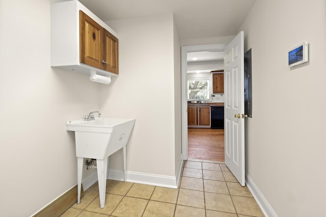 bathroom featuring tile patterned flooring, a sink, and baseboards