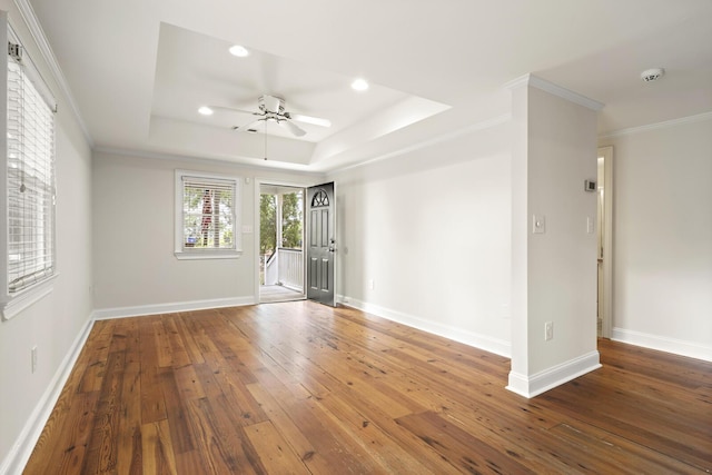 spare room featuring hardwood / wood-style flooring, baseboards, and a raised ceiling