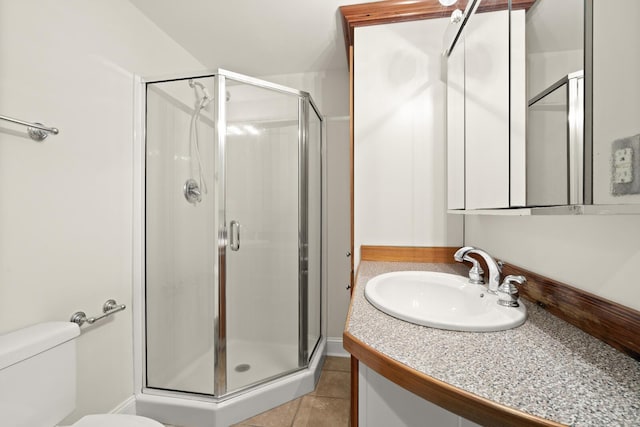 bathroom featuring vanity, tile patterned flooring, a shower stall, and toilet