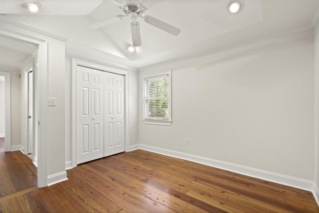 unfurnished bedroom with crown molding, dark wood-style flooring, a closet, and baseboards