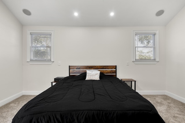 carpeted bedroom with lofted ceiling, multiple windows, and baseboards