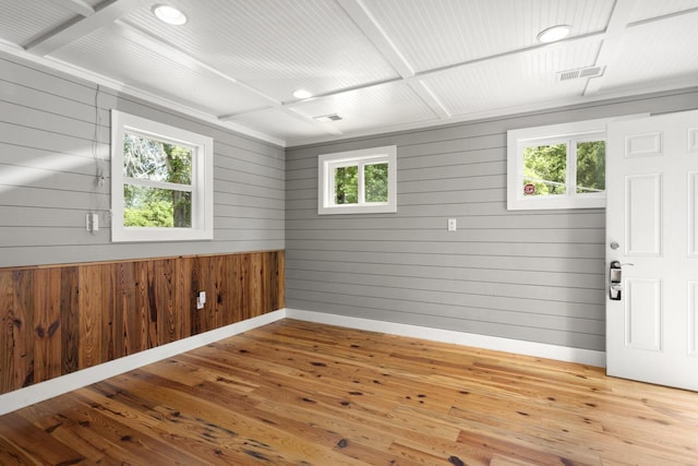 empty room with plenty of natural light, hardwood / wood-style flooring, and baseboards