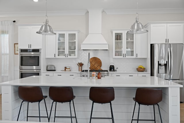 kitchen featuring decorative backsplash, custom exhaust hood, crown molding, and appliances with stainless steel finishes