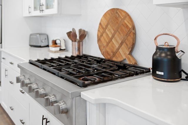 interior details featuring glass insert cabinets, white cabinetry, and light countertops