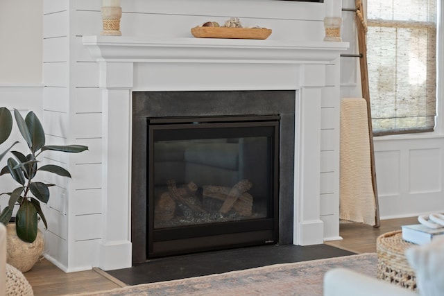 interior details featuring a glass covered fireplace and wood finished floors