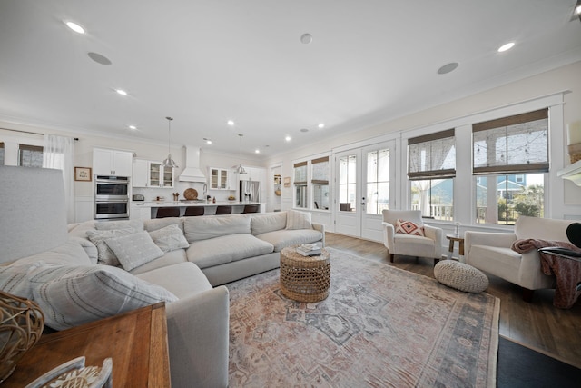 living room featuring wood finished floors, a wealth of natural light, and ornamental molding