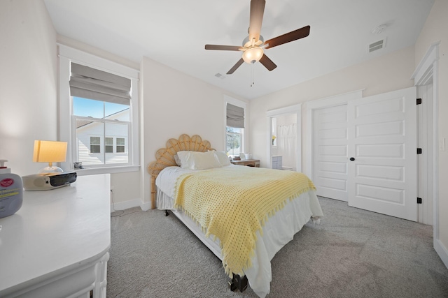 bedroom featuring visible vents, multiple windows, and light colored carpet