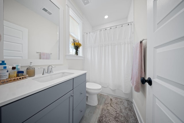 full bath featuring visible vents, toilet, vanity, and shower / bath combo