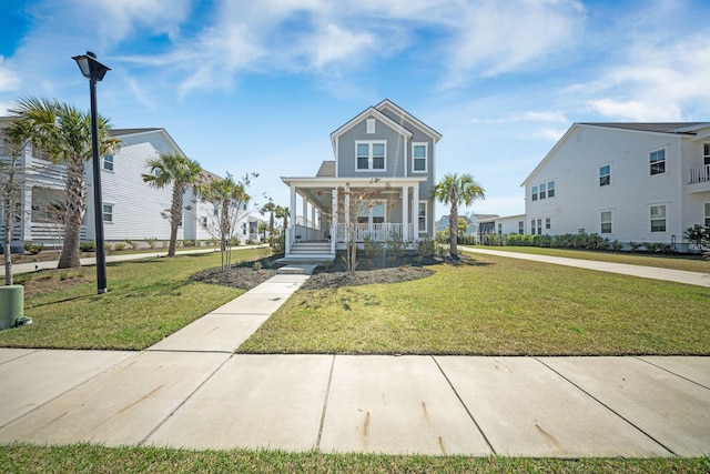 coastal inspired home featuring a porch and a front yard