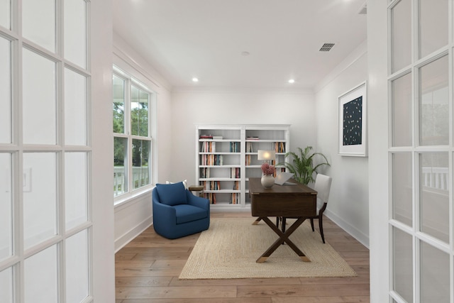 living area featuring light wood-type flooring and ornamental molding