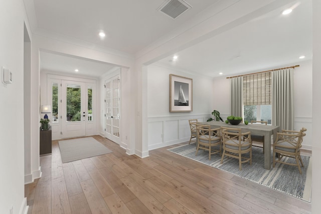 dining area with light hardwood / wood-style floors and ornamental molding