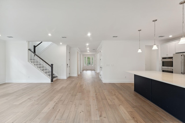 unfurnished living room featuring crown molding and light hardwood / wood-style floors