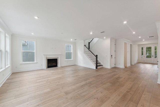 unfurnished living room featuring light wood-type flooring and a wealth of natural light