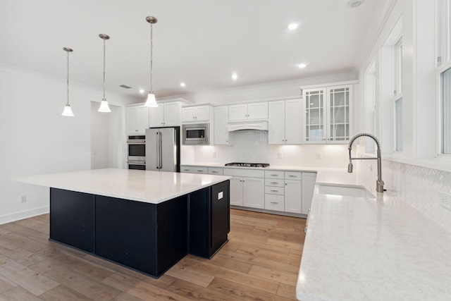 kitchen with a center island, sink, stainless steel appliances, light hardwood / wood-style flooring, and white cabinets