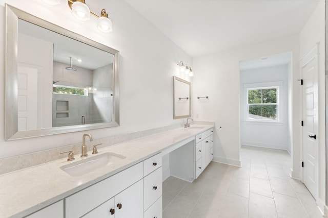 bathroom with a shower with door, vanity, and tile patterned flooring