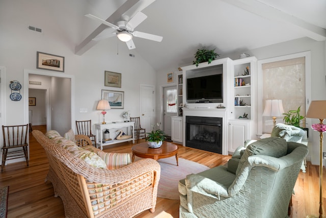 living room featuring high vaulted ceiling, ceiling fan, beamed ceiling, and light wood-type flooring