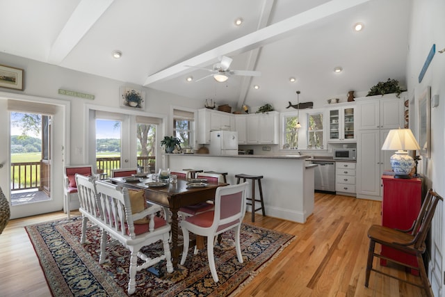 dining space with light wood-type flooring, beamed ceiling, and high vaulted ceiling