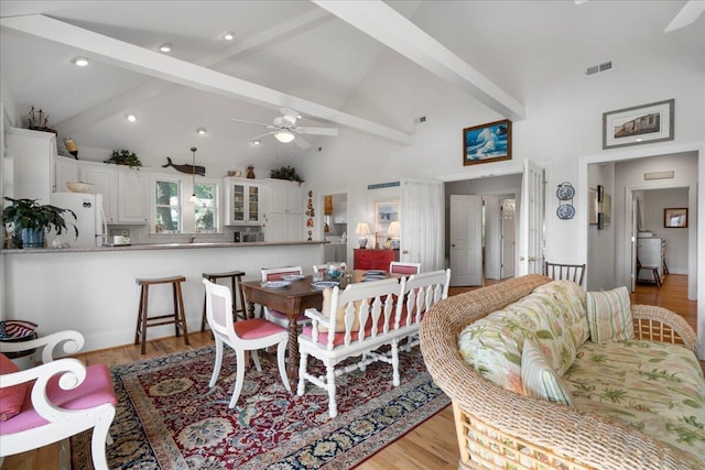 dining room with high vaulted ceiling, ceiling fan, beamed ceiling, and light wood-type flooring