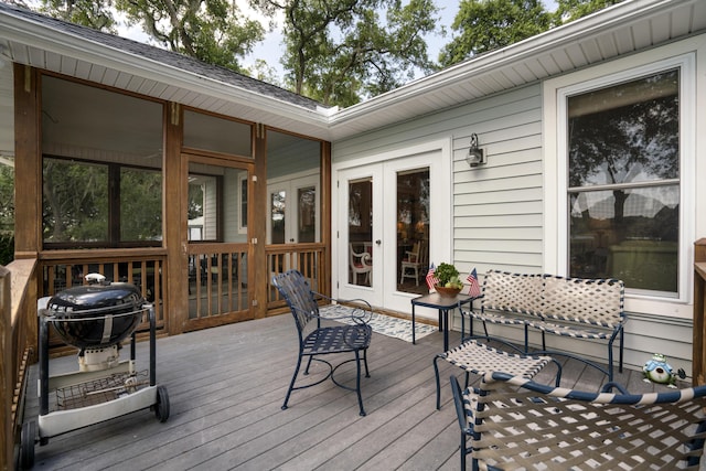 wooden deck with a grill and french doors