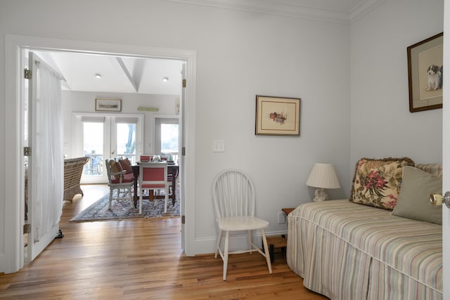 sitting room with ornamental molding, light wood-type flooring, and french doors