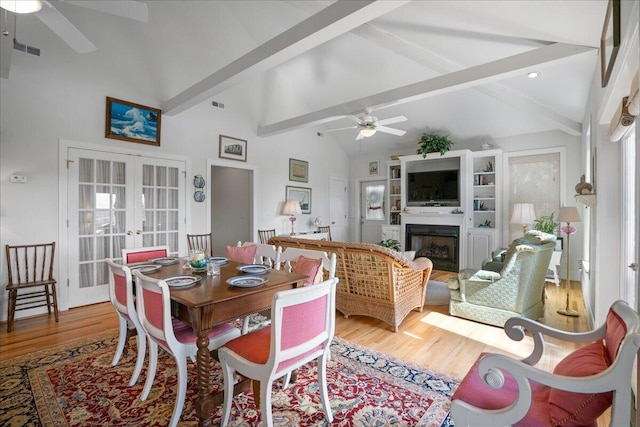 dining space with light hardwood / wood-style flooring, ceiling fan, french doors, beam ceiling, and high vaulted ceiling