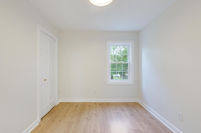 spare room with light wood-type flooring and baseboards