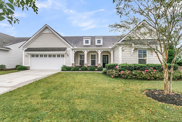 view of front of property featuring a garage, covered porch, and a front yard