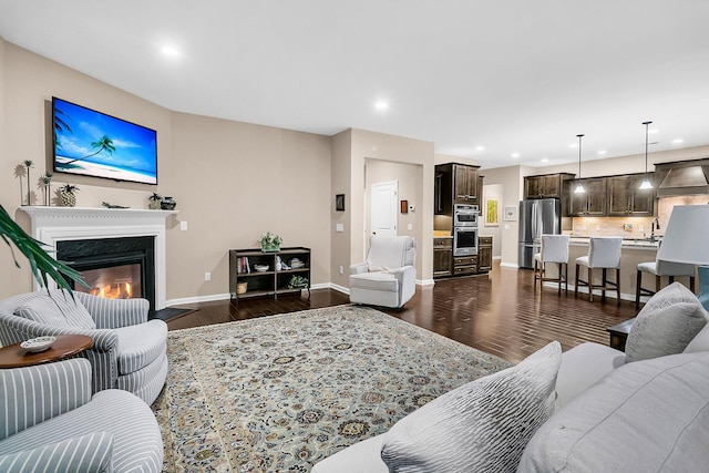 living room featuring sink, a fireplace, and dark wood-type flooring