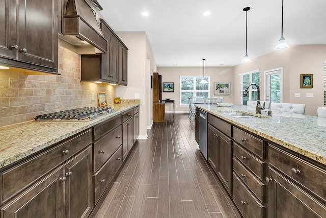 kitchen with dark brown cabinets, sink, custom exhaust hood, decorative light fixtures, and dark hardwood / wood-style flooring