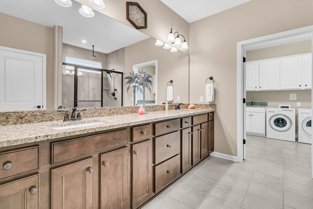 bathroom with walk in shower, vanity, tile patterned flooring, and washer and dryer