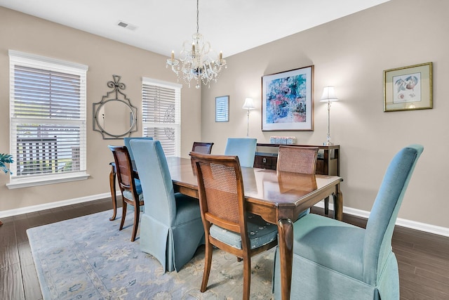 dining room with a healthy amount of sunlight, dark hardwood / wood-style floors, and a notable chandelier