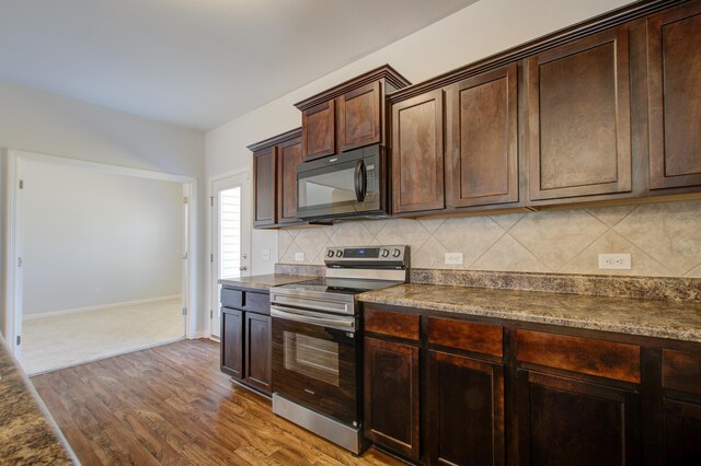 491 Fox Sparrow Ct, Summerville, SC 29486 - kitchen featuring dark brown cabinetry, backsplash, black microwave, stainless steel range with electric cooktop, and wood finished floors