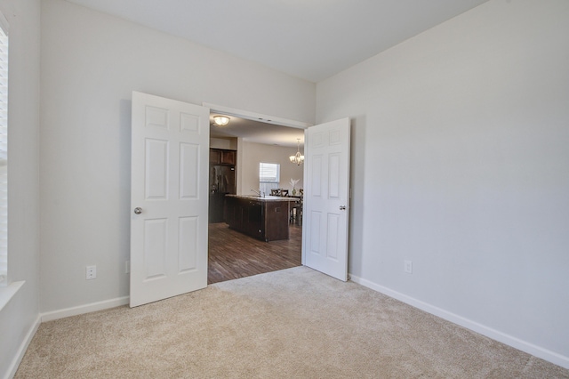 491 Fox Sparrow Ct, Summerville, SC 29486 - empty room with baseboards, dark carpet, a chandelier, and a sink