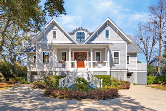 view of front of property with stairway, covered porch, and concrete driveway