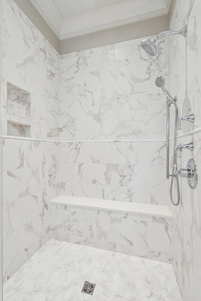 bathroom featuring crown molding and a tile shower