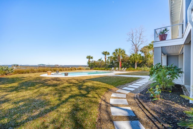 view of yard with an outdoor pool and a balcony