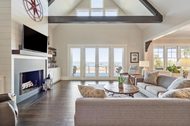 living area featuring dark wood finished floors, beamed ceiling, a fireplace, french doors, and high vaulted ceiling