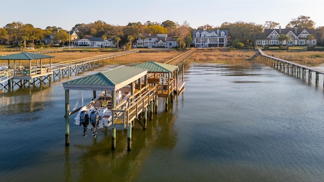 view of dock with a residential view and a water view