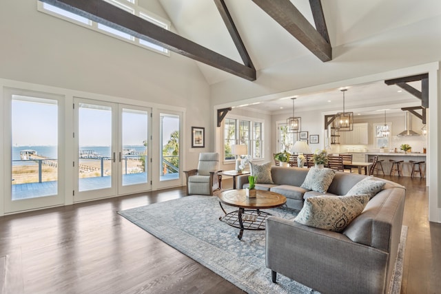 living area with a wealth of natural light, french doors, beam ceiling, and dark wood-type flooring