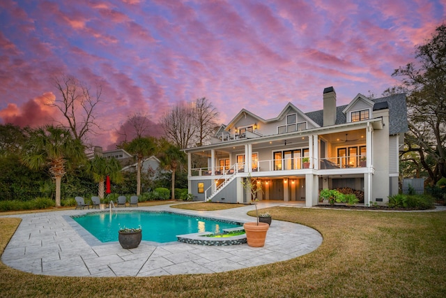 back of house at dusk featuring stairs, a yard, a patio area, and ceiling fan