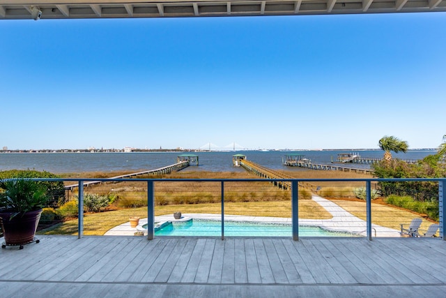 wooden deck featuring a fenced in pool and a water view